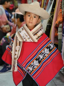 Child wearing handmade Serape poncho in Peru – representing Latin heritage and craftsmanship