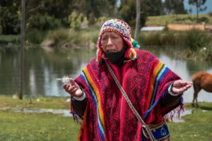 Man in bright woven poncho beside water – authentic handwoven poncho Mexico