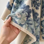 Close-up of the blue BloomWrap floral textile, decorative border and fringed edge