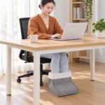 FootNest electric foot warmer used while seated at a desk