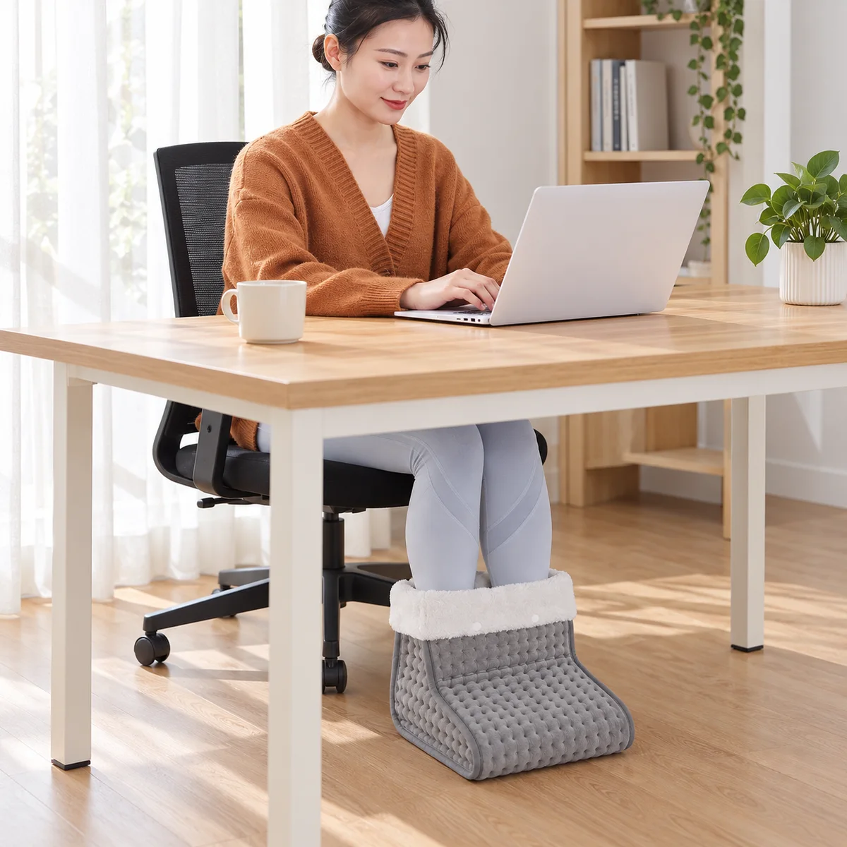 FootNest electric foot warmer used while seated at a desk