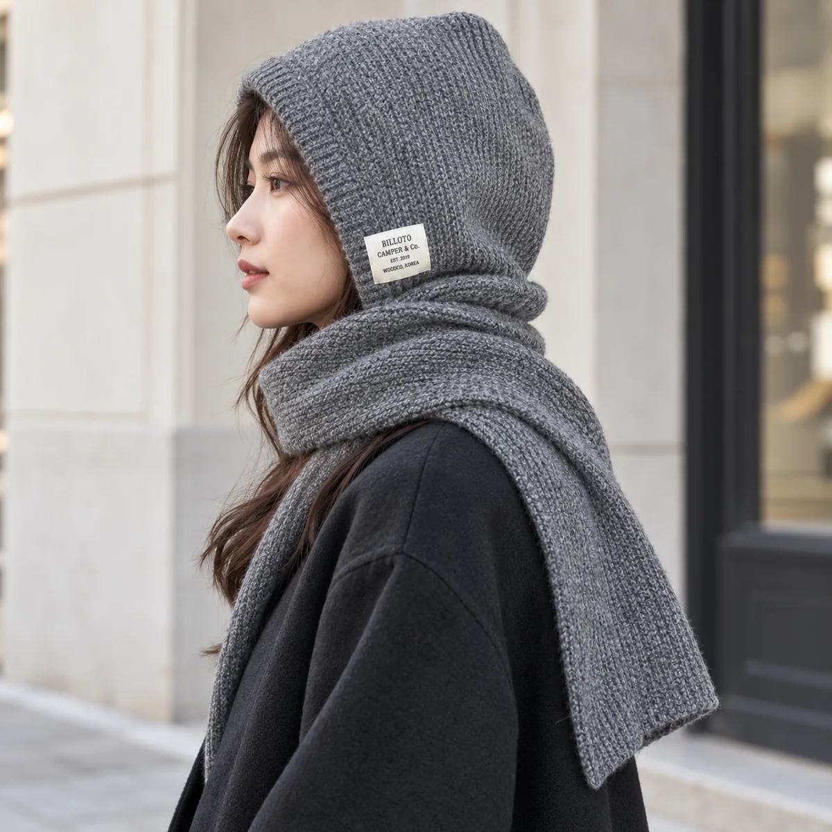 Side view of the grey FrostHood knitted hooded scarf covering head and neck