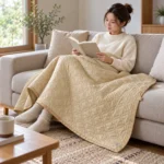 Naturehike khaki quilted nylon heated blanket draped over an adult's lap indoors